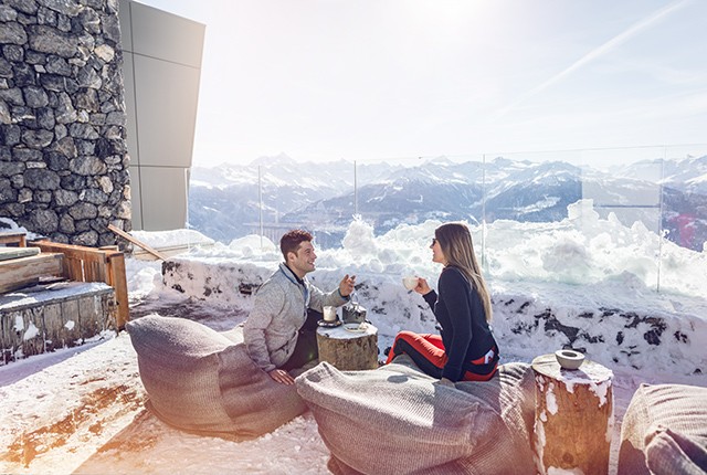 Valais: Apres ski, couple, mountains in background.