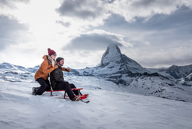 Sledding at Zermat Gornergrat, couple, Matterhorn.