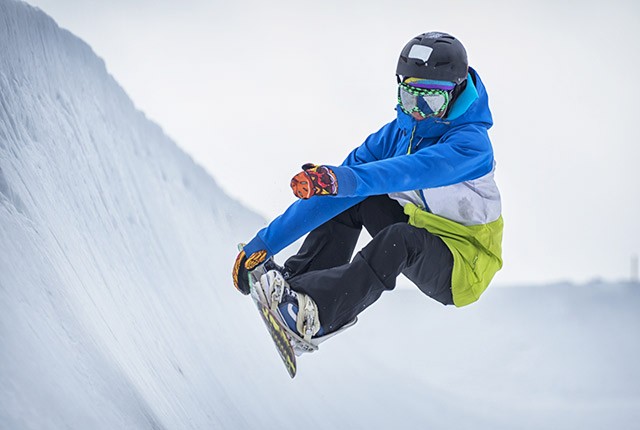 Snowboarder on half pipe in air.